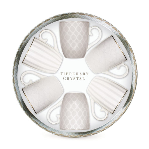 A circular gift box containing six white ceramic cups arranged in a circle, with the words 'Tipperary Crystal' printed in the center. The cups are white with subtle gray and gold patterns and borders, set against a clean white background.